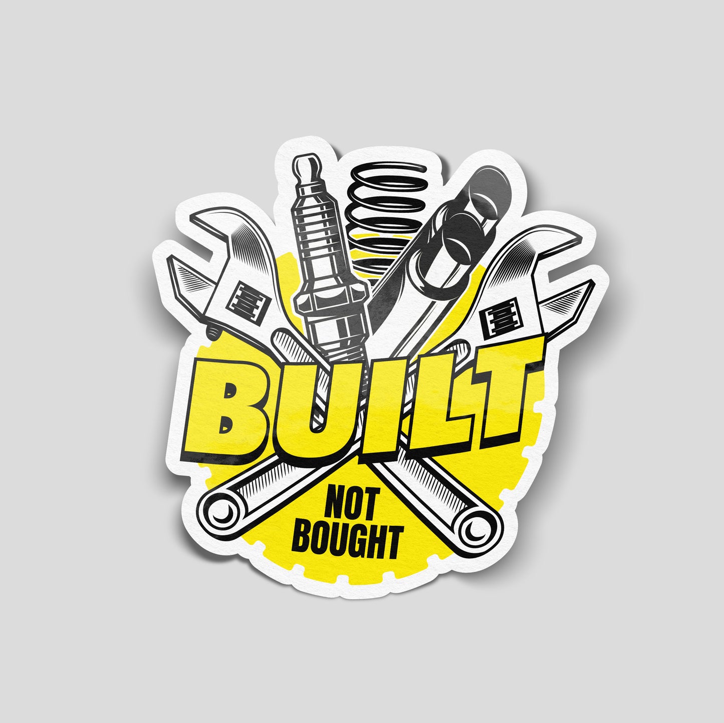 Yellow illustrated funny car sticker showing wrenches, springs and car parts with the text “Built Not Bought”, UK car enthusiast decal.