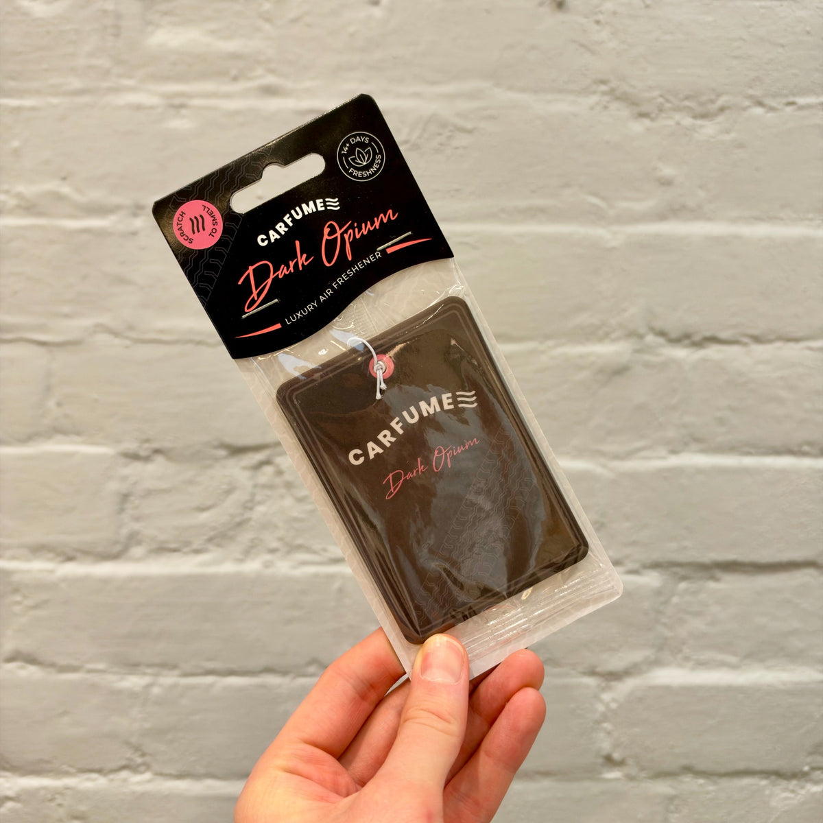 Carfume Dark Opium hanging car air freshener in black packaging with red lettering.