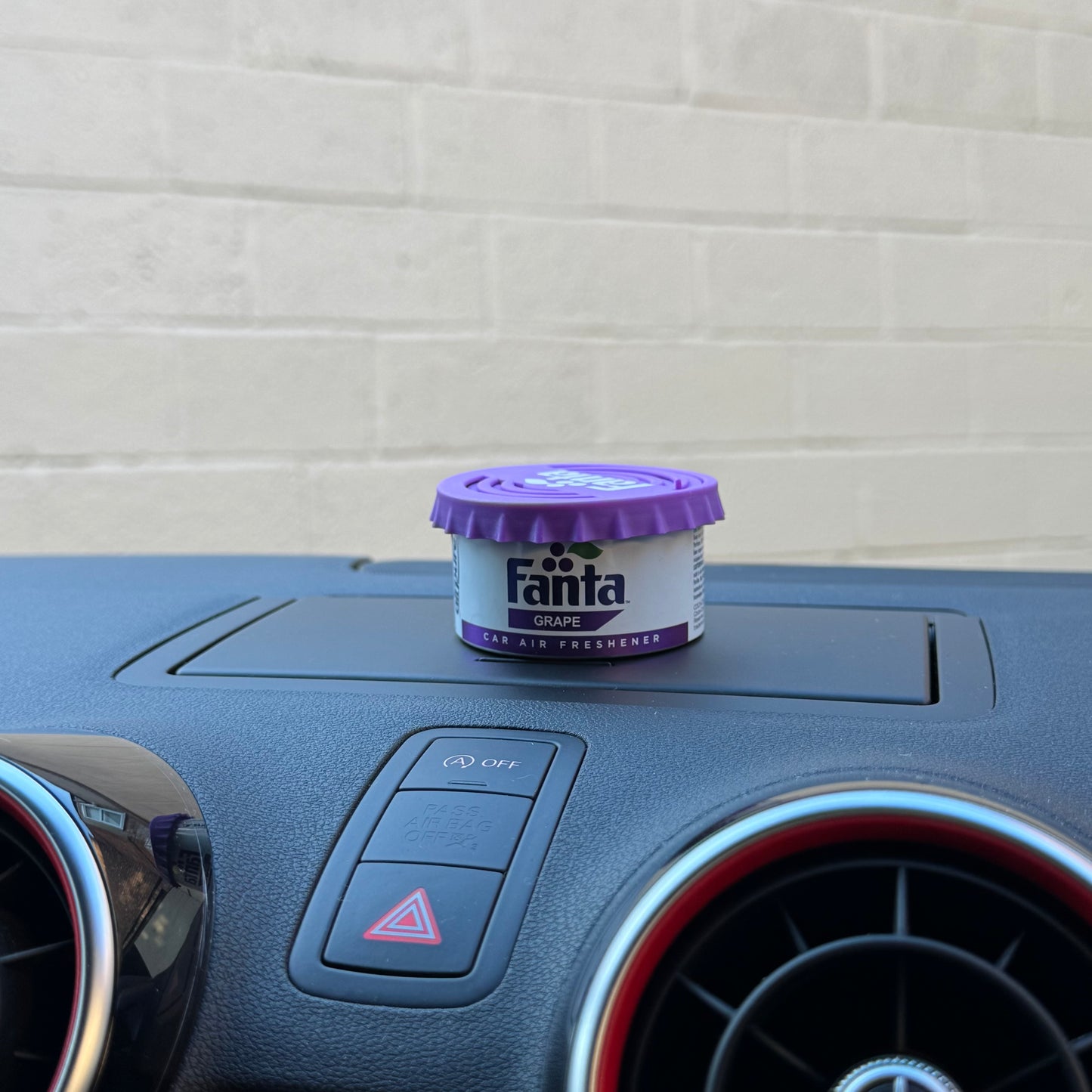 Fanta Grape Twist Tin Car Air Freshener on Car Dashboard.