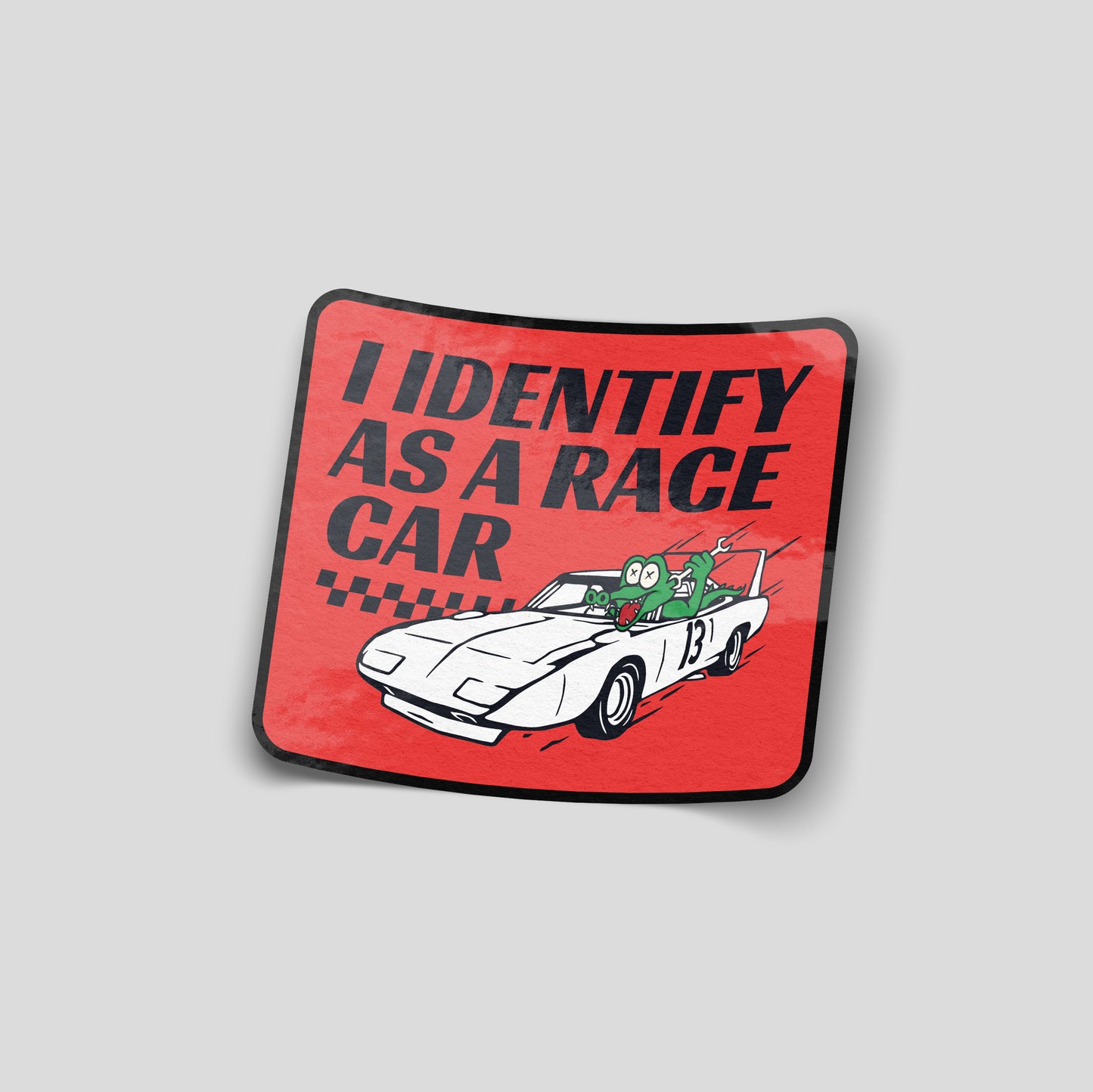 Red “I identify as a race car” funny car sticker with cartoon character driving a sports car, UK automotive humour decal.