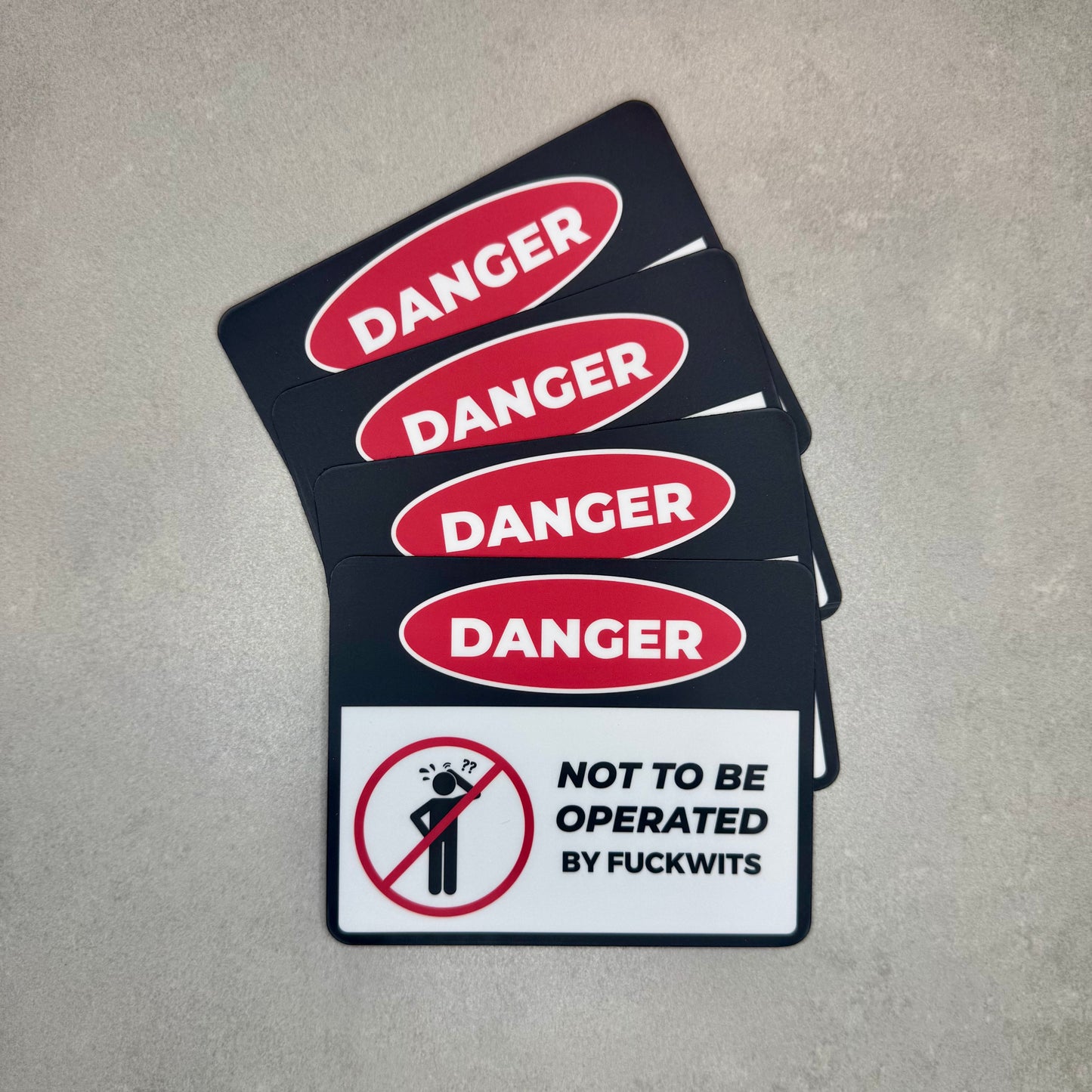 Danger Not To Be Operated By Fuckwits funny magnet stack styled like a classic danger warning sign. Removable novelty toolbox or fridge magnet made using strong 0.8mm magnetic sheeting by Blum Decals UK.