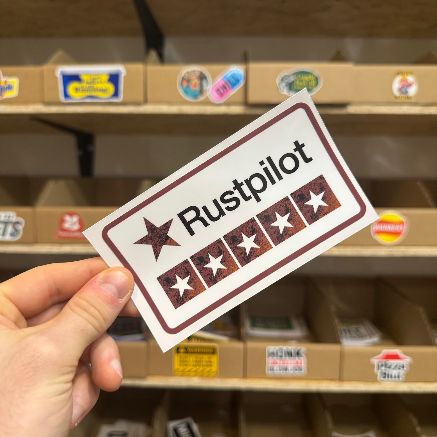 Rust-themed parody review sticker labelled ‘Rustpilot’ with a row of distressed star ratings.