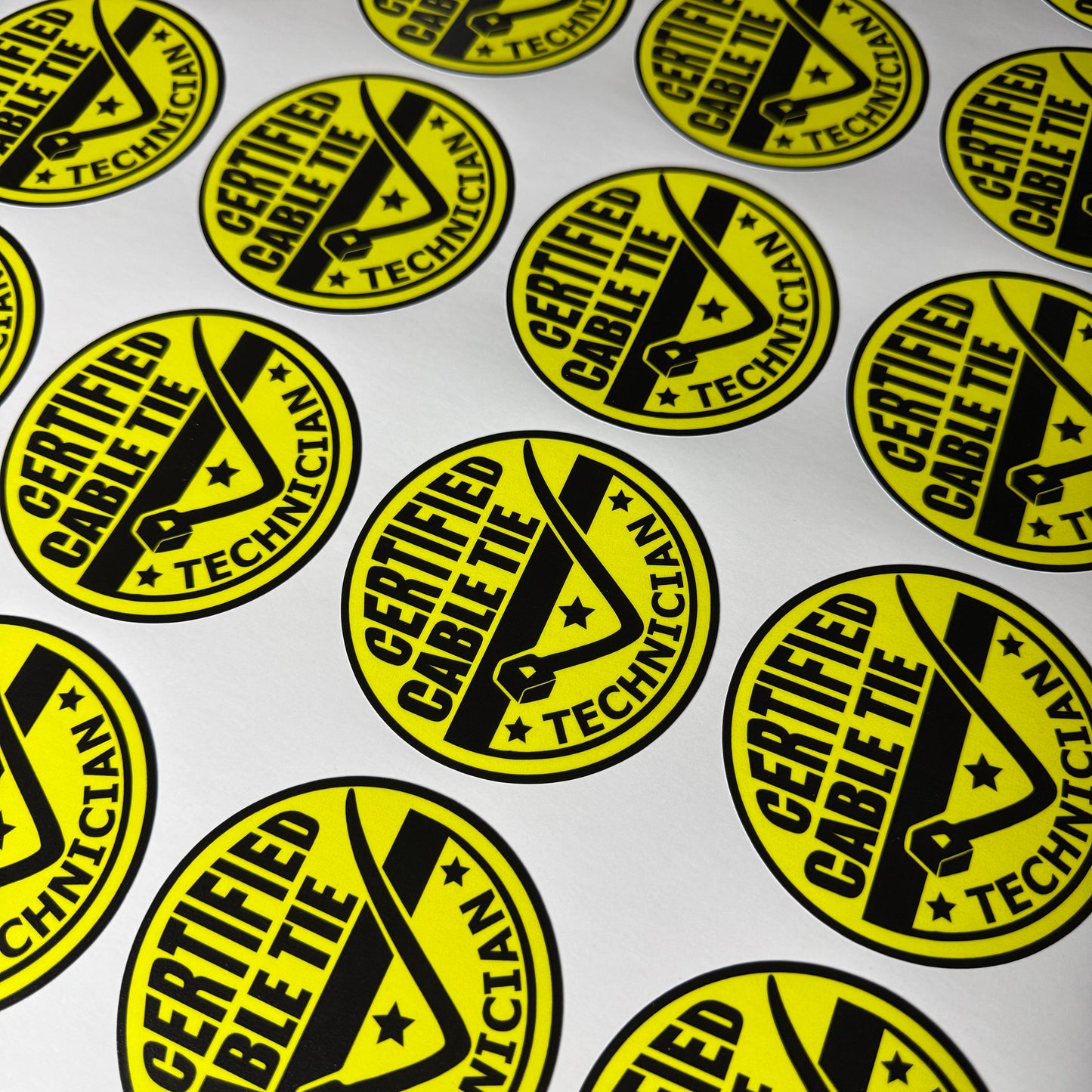 Sheet of Yellow and black certified cable tie technician vinyl decal stickers for cars , toolboxes or as a funny sticker joke.