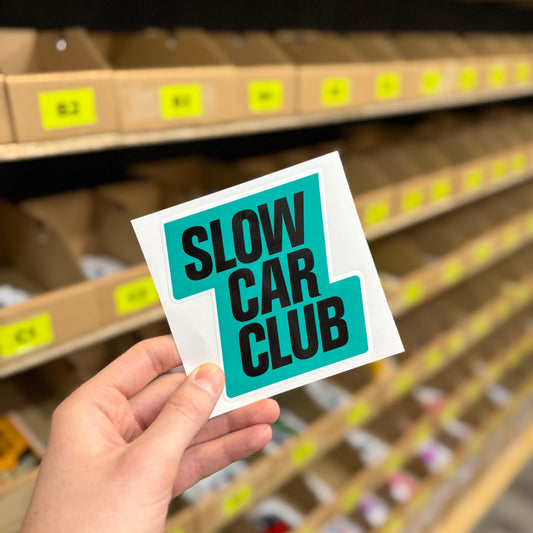 Slow Car Club funny vinyl car sticker in teal and black design, gloss waterproof laminated decal held in hand, UK made car enthusiast sticker by Blum Decals.