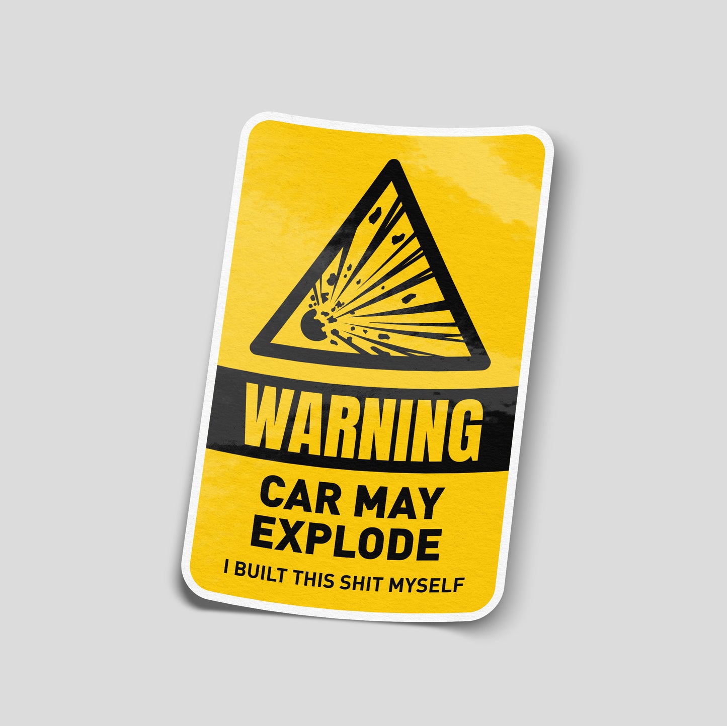 Yellow warning‑label funny car sticker with an explosion triangle icon and text claiming the car may explode, UK motoring humour decal.