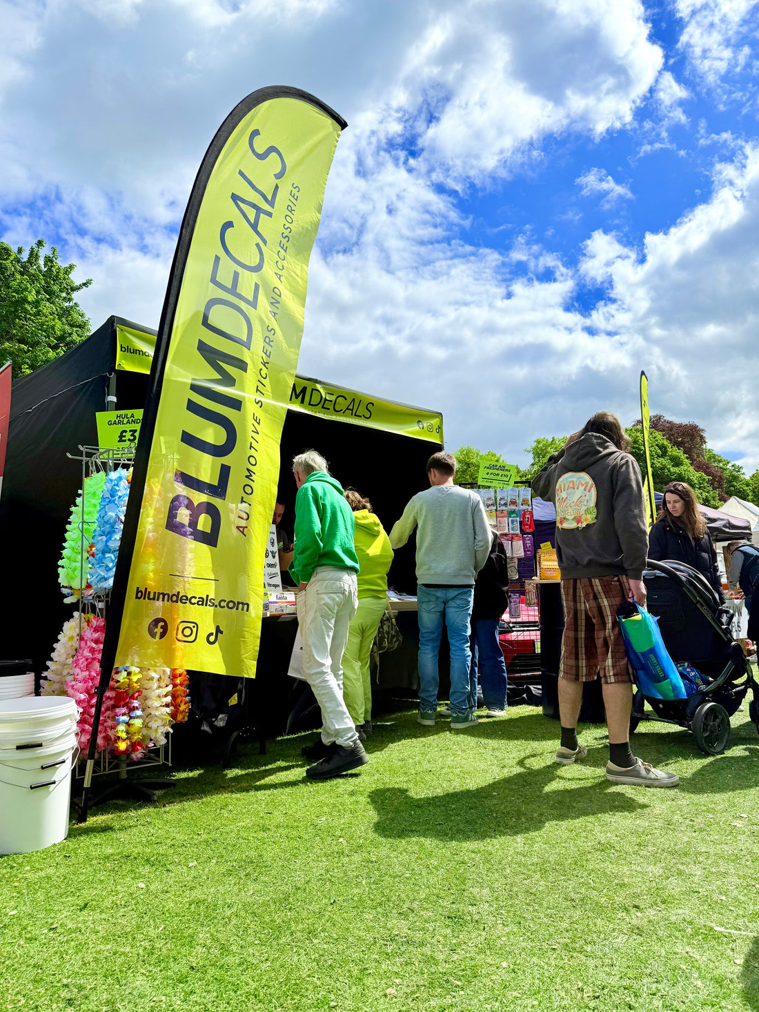 Blum Decals trade stand at the 2024 Stanford Hall VW Show, featuring branded signage, automotive stickers display, and visitors browsing in sunny weather.