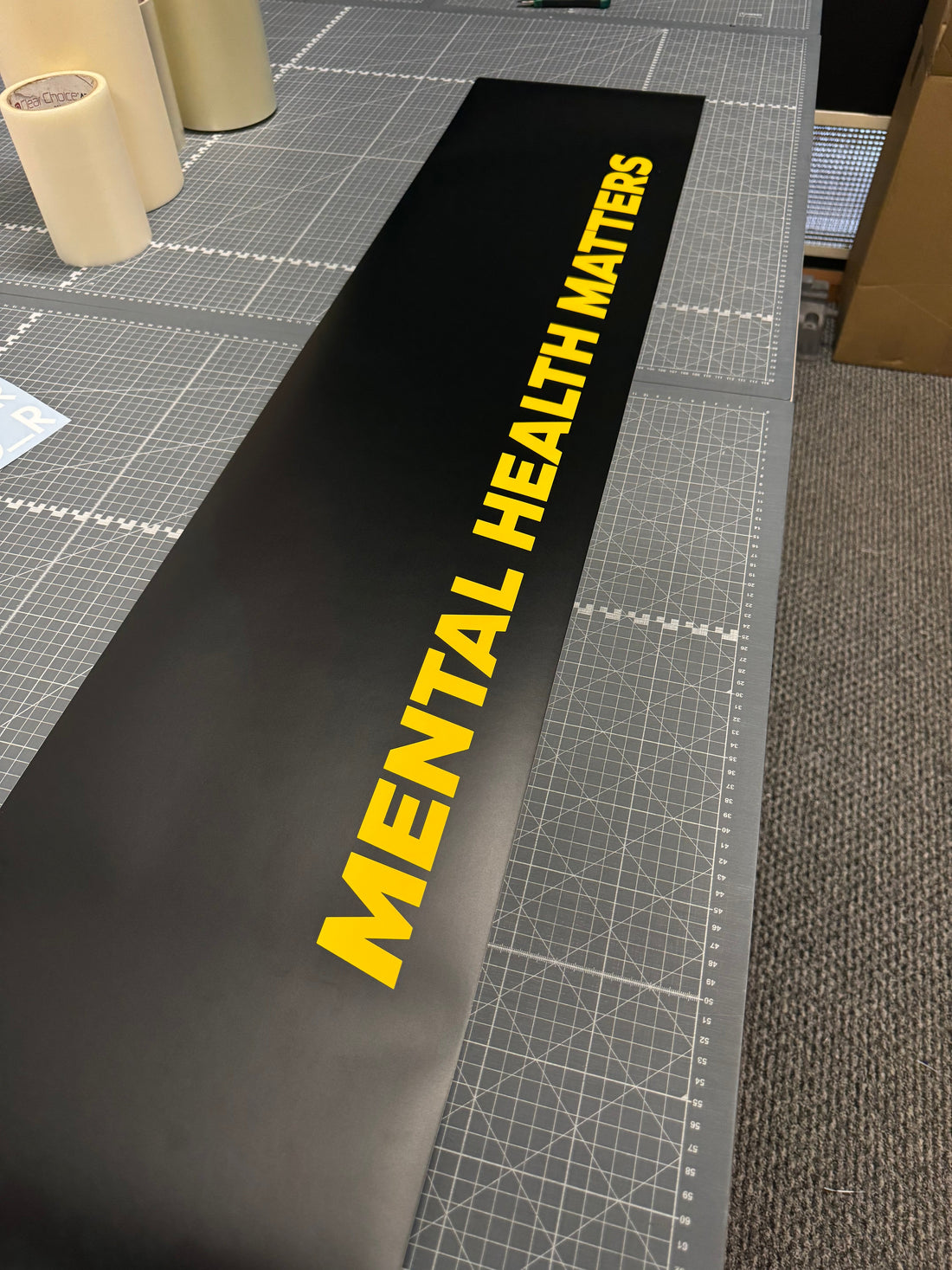 Black vinyl sunstrip with bold yellow "Mental Health Matters" text, designed for car windshields. Custom personalised sun strip for Ford Fiesta and other vehicles.