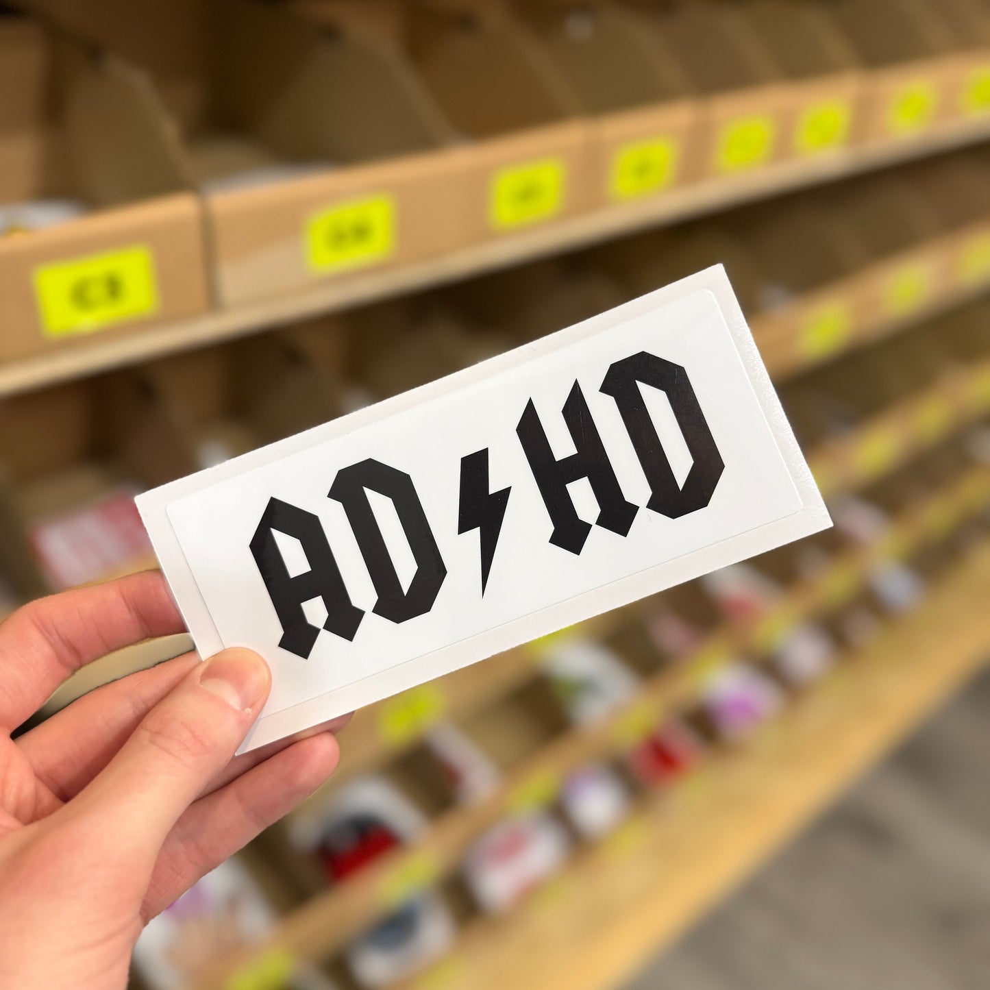 Funny rock music parody sticker inspired by AC/DC logo with bold black lettering