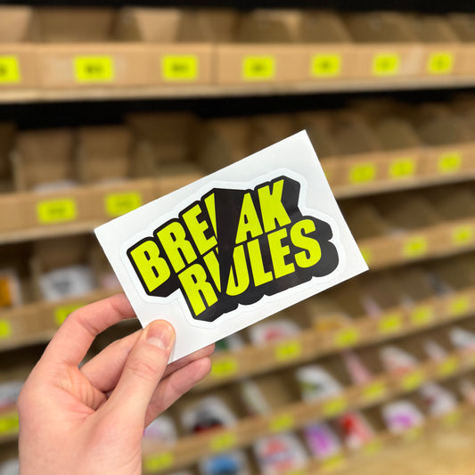 Funny slogan sticker reading “break rules” in bold yellow and black text