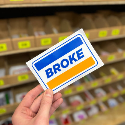 Funny parody fuel style sticker reading “broke” in bold blue and orange design