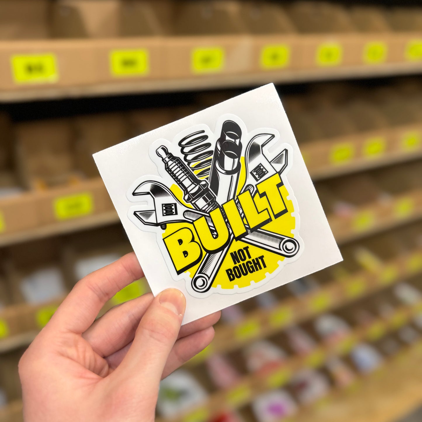 Funny car enthusiast sticker reading “built not bought” with tools illustration