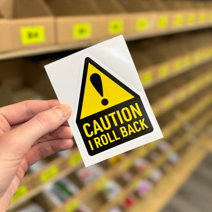 Funny warning sticker reading “caution I roll back” yellow hazard sign design