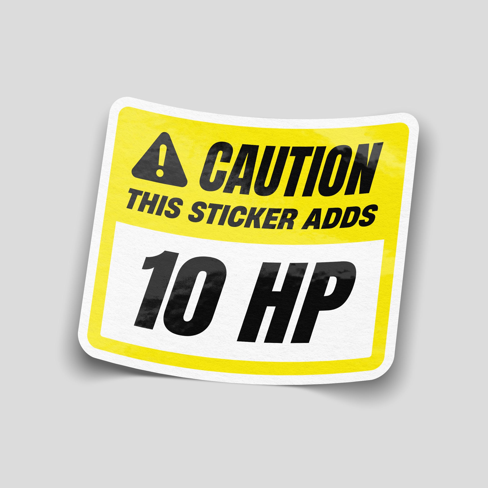 Yellow warning‑style funny car sticker reading “Caution This Sticker Adds 10 HP” with hazard icon, UK car humour vinyl decal.