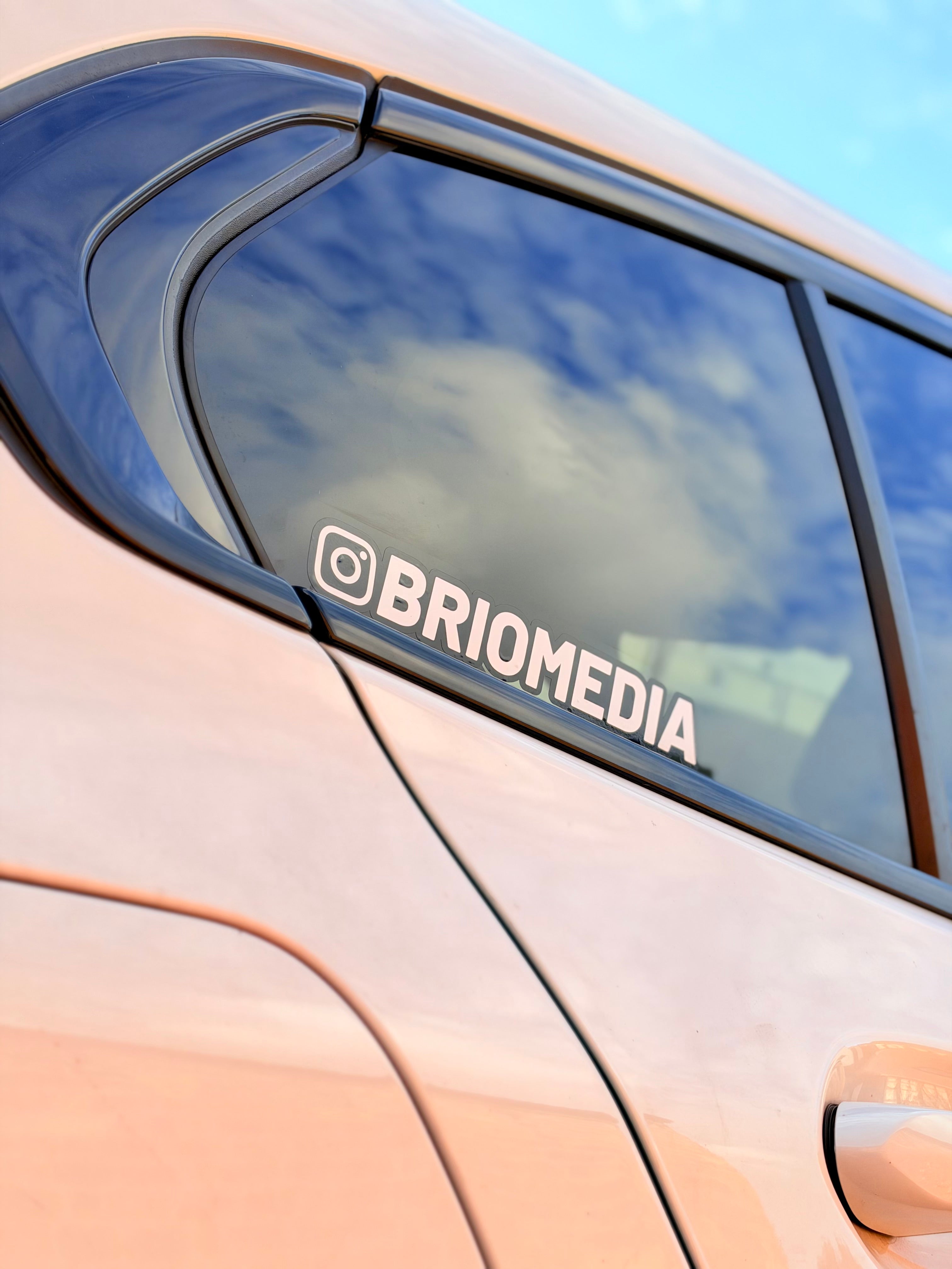 Custom Brio Media Instagram sticker displayed on a car's rear tinted window, showcasing branded vehicle graphics and creative promotional design.