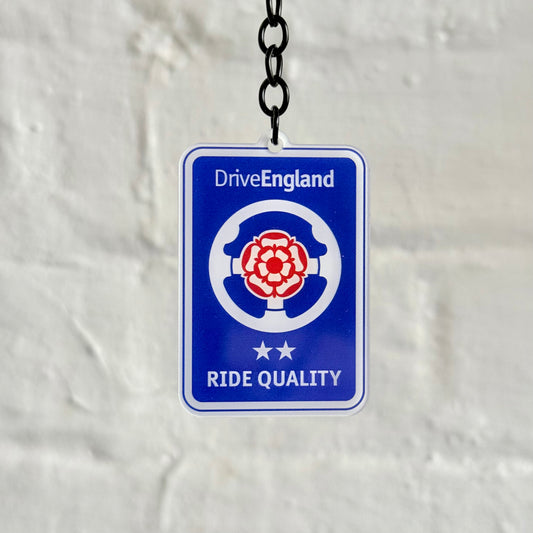 Funny “Drive England Ride Quality” acrylic keychain with blue badge and rose design, glossy finish and black chain, perfect UK car enthusiast gift.