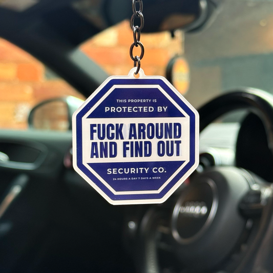 Blue “F*ck Around And Find Out” security sign style acrylic keychain hanging inside car with black chain