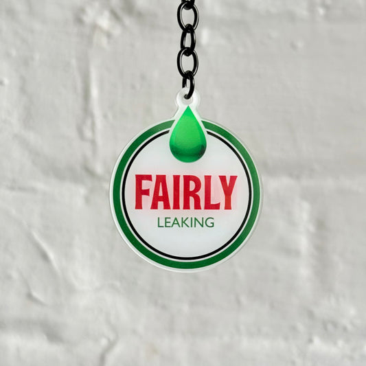 Funny “Fairly Leaking” acrylic keychain with oil drip design, glossy double-sided print and black chain, ideal for project cars and unreliable builds.