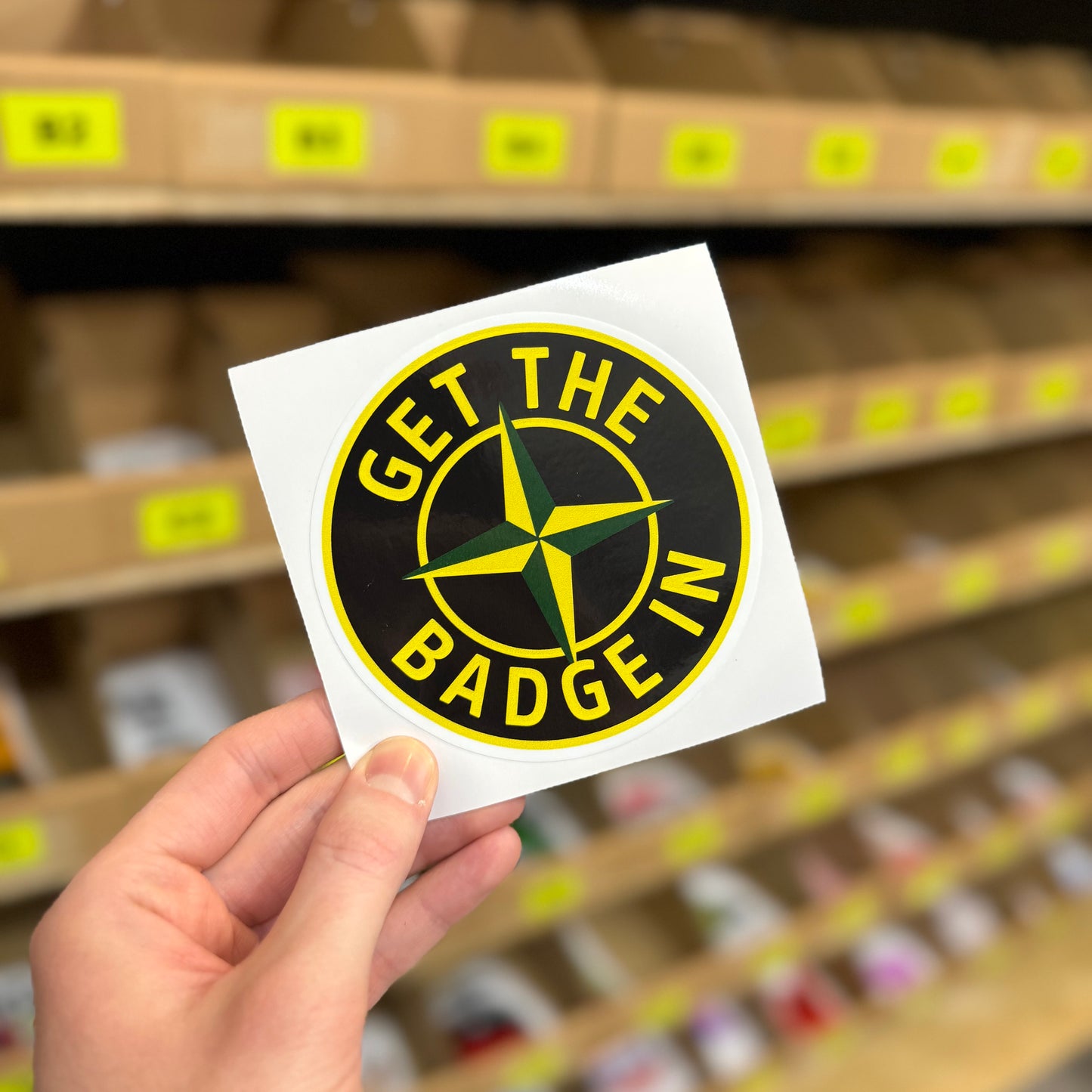 Funny car culture sticker reading “get the badge in” compass style design