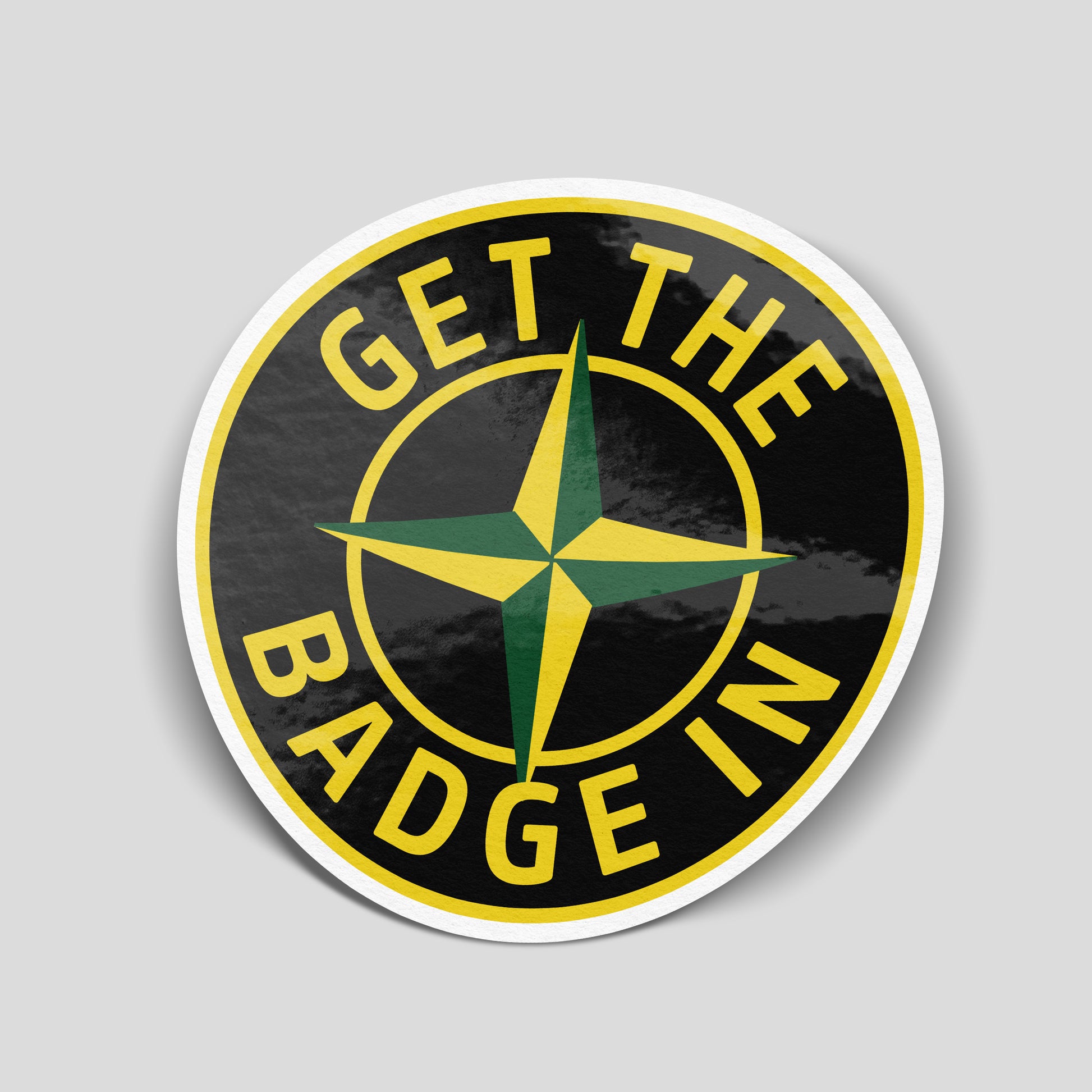 Round “Get the Badge In” funny car sticker with green and yellow compass‑style emblem, UK pub and motoring humour decal.