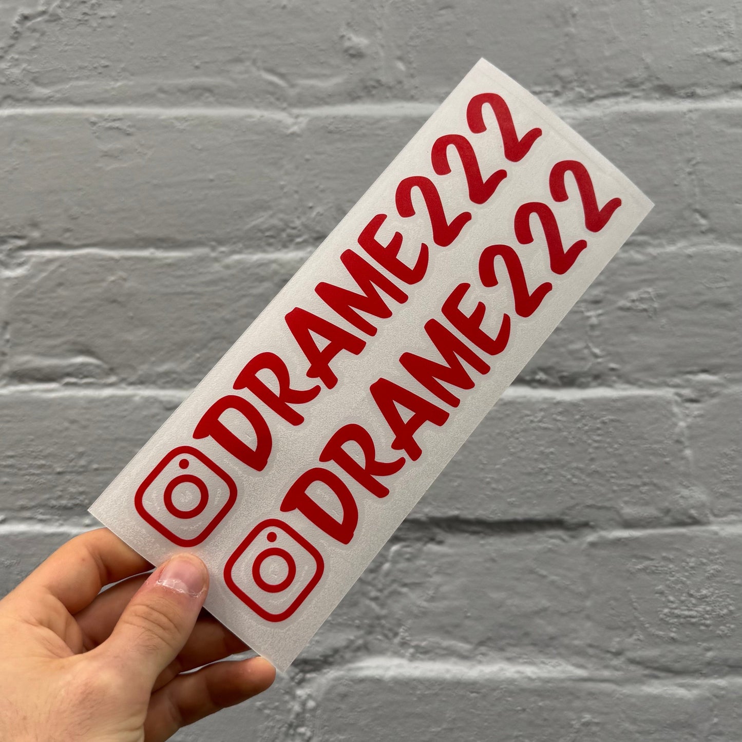 Custom gloss red Instagram handle stickers with black outline, personalised Instagram vinyl decals supplied as a pair
