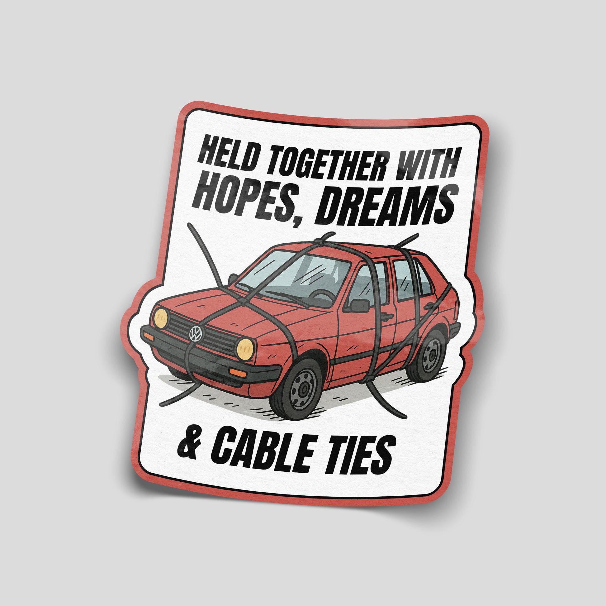 Illustrated funny car sticker showing an old red car strapped together with cable ties, captioned “Held together with hopes, dreams & cable ties”, UK motoring humour decal.