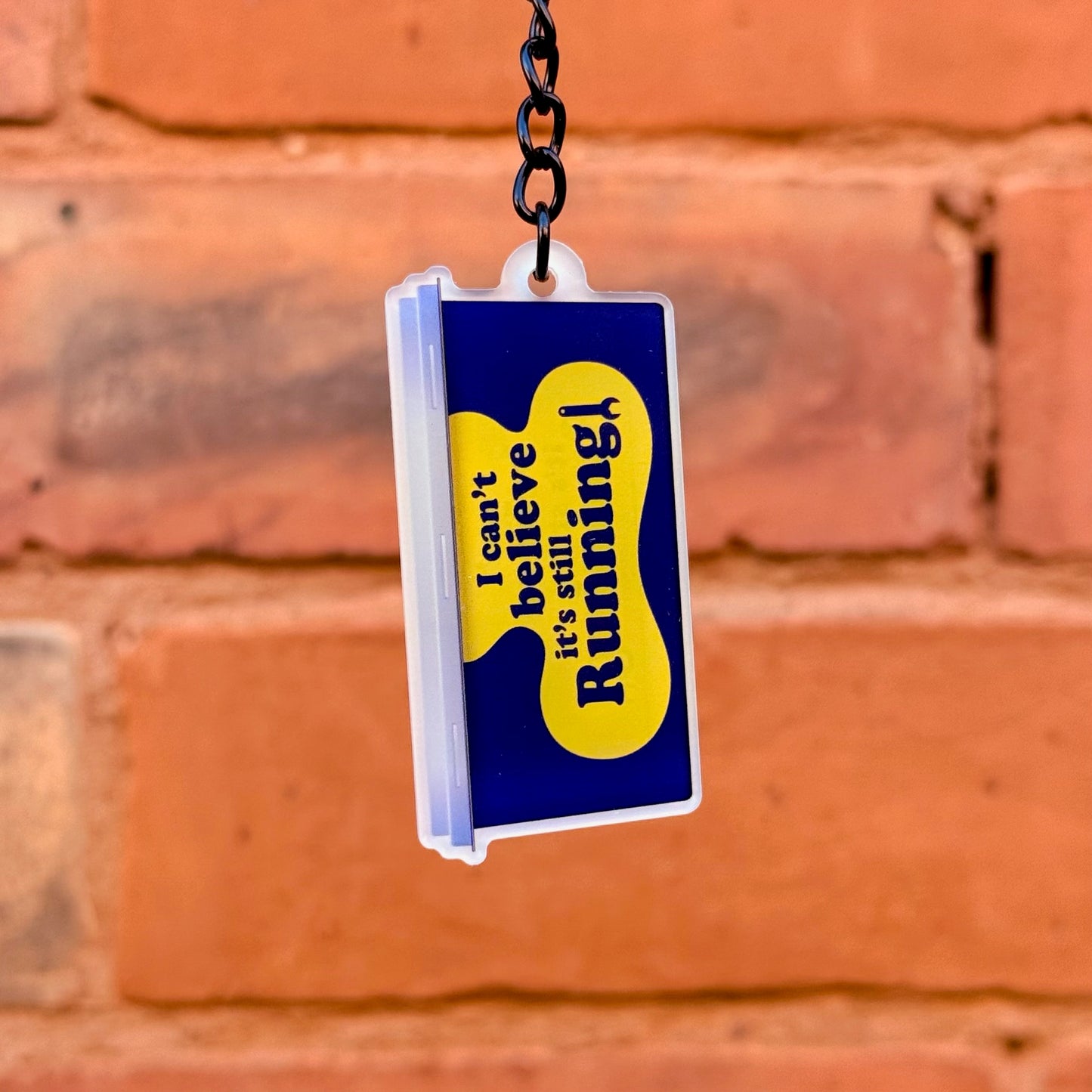 Can't Believe It's Still Running funny acrylic keychain with double-sided print and gloss black chain