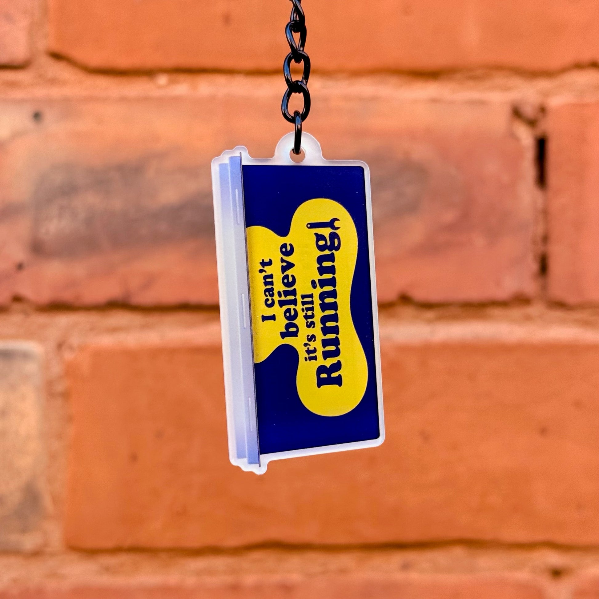Can't Believe It's Still Running funny acrylic keychain with double-sided print and gloss black chain