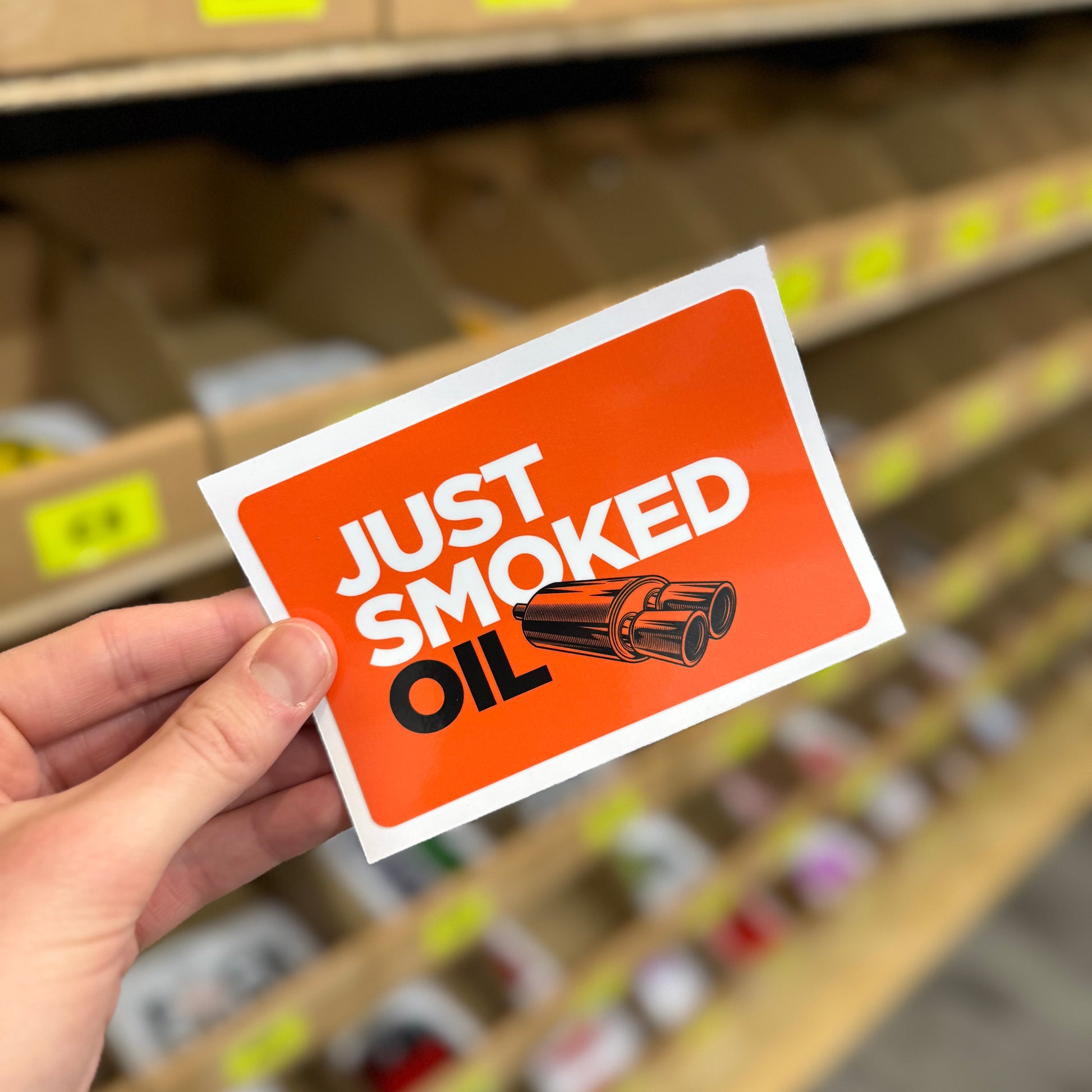 Funny car sticker reading “just smoked oil” with exhaust pipes illustration