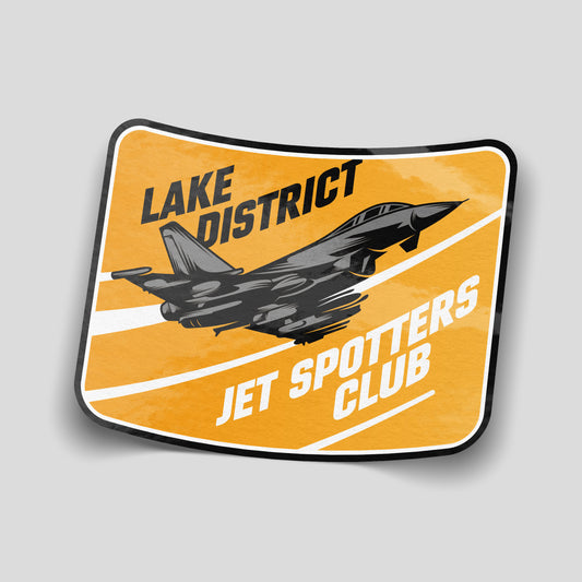 Orange Lake District Jet Spotters Club sticker featuring a grey military jet, white streaks and black and white lettering.