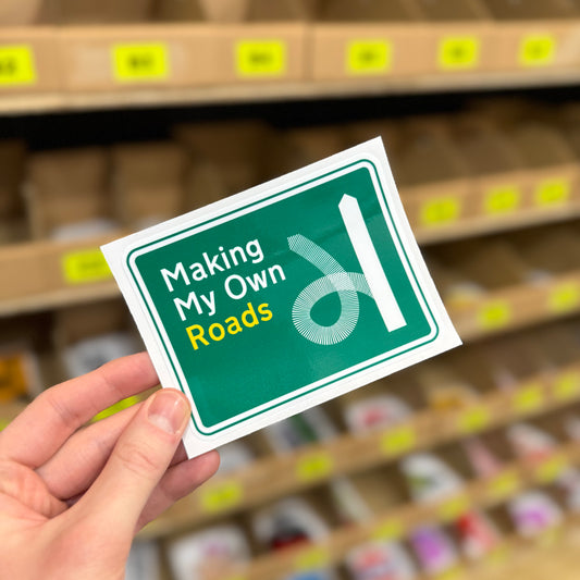 Funny road sign parody sticker reading “making my own roads” green motorway style design