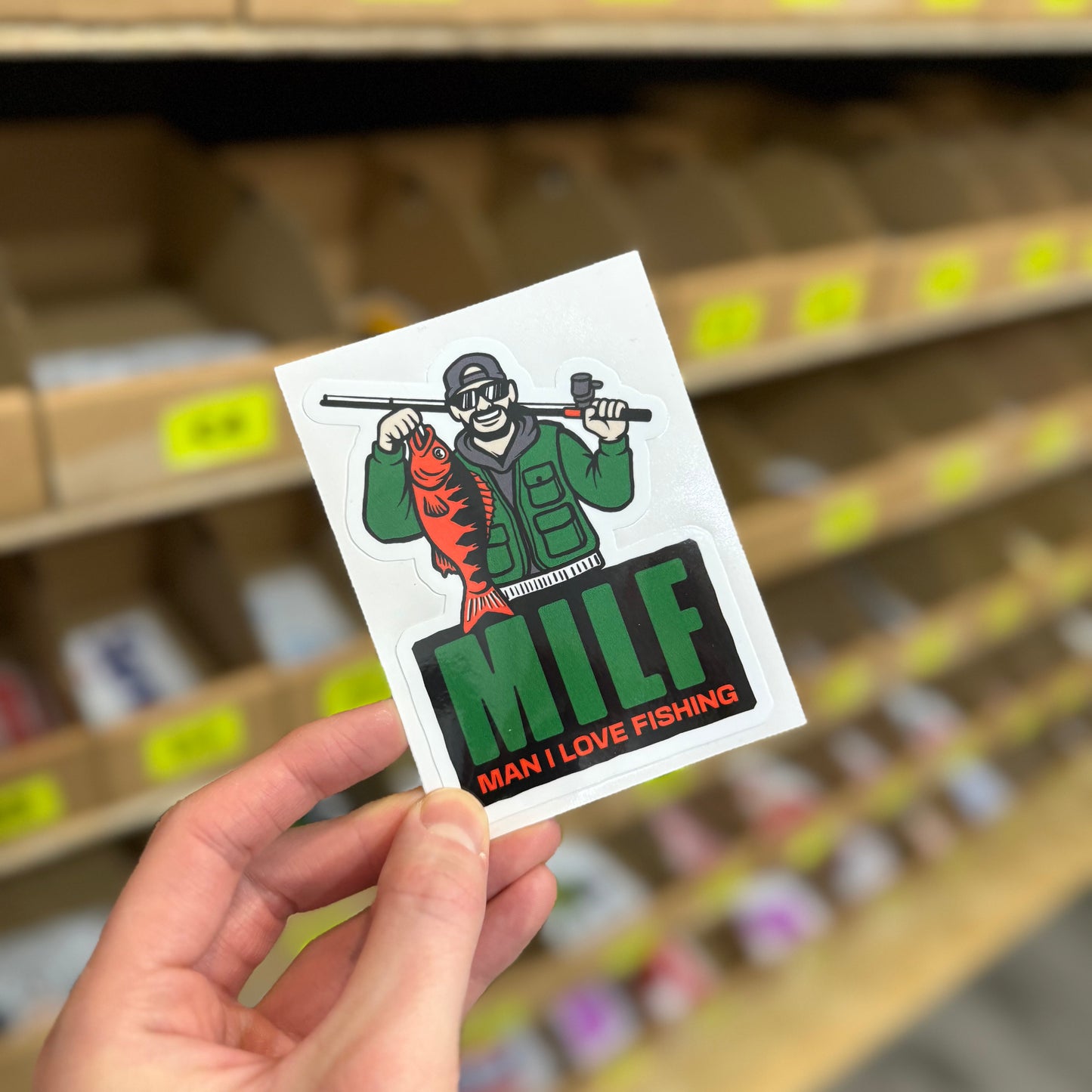 Funny fishing sticker showing angler holding fish with “man I love fishing” text