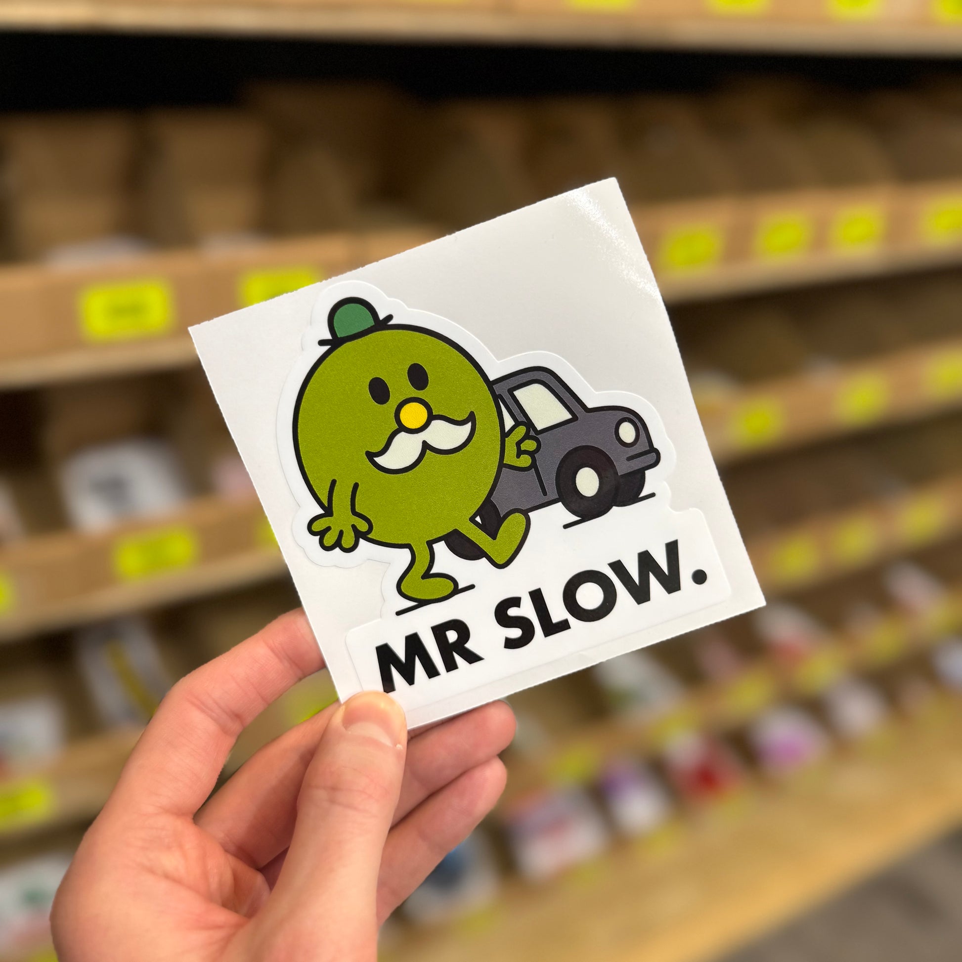 Funny car sticker showing cartoon character walking beside car with “mr slow” text