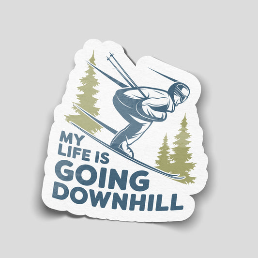 My Life Is Going Downhill skiing sticker with a blue skier, green pine trees and bold blue lettering on a white background.