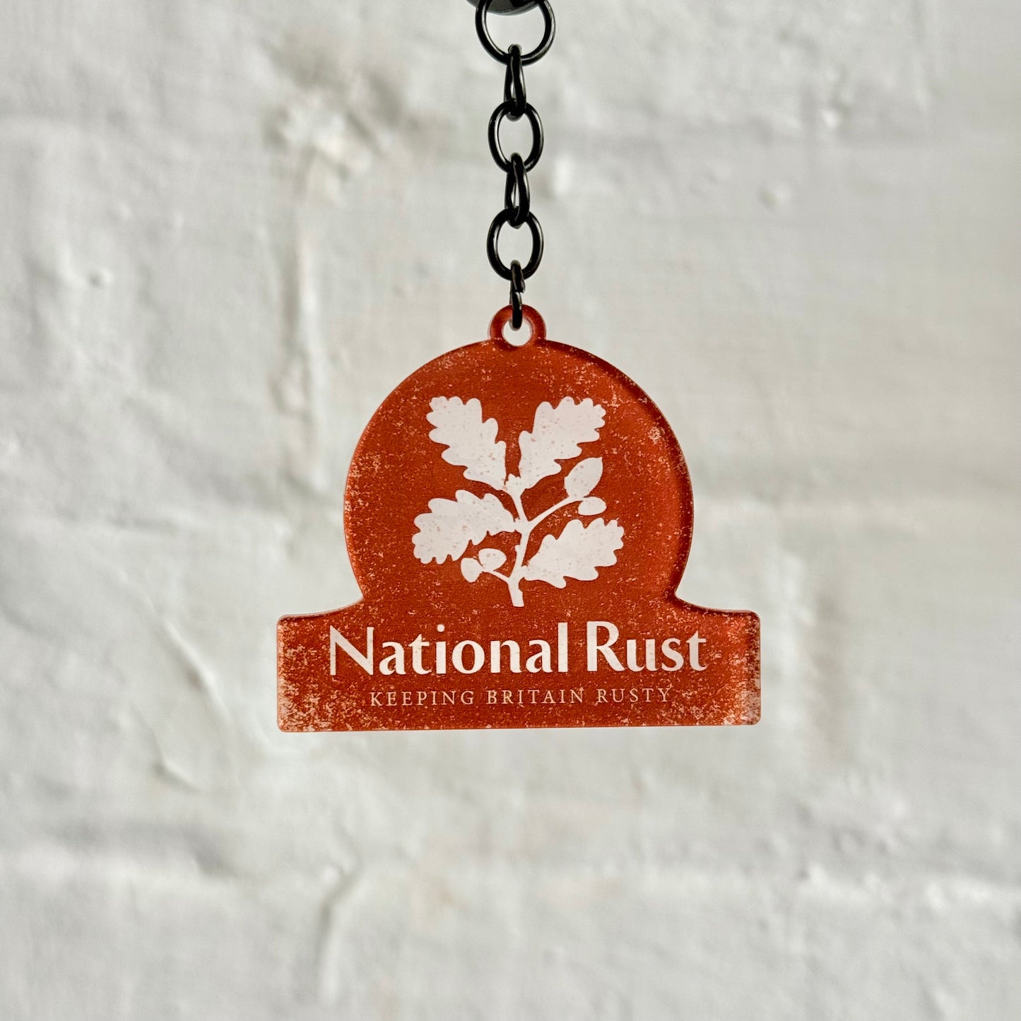 Funny “National Rust” acrylic keychain with distressed orange design, glossy finish and black chain, ideal for classic car lovers and rusty project builds.