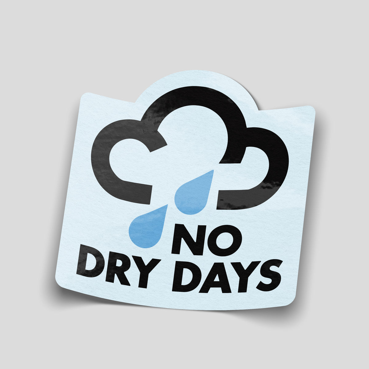 No Dry Days adventure sticker with a black rain cloud, two blue raindrops and bold black lettering on a pale blue background.