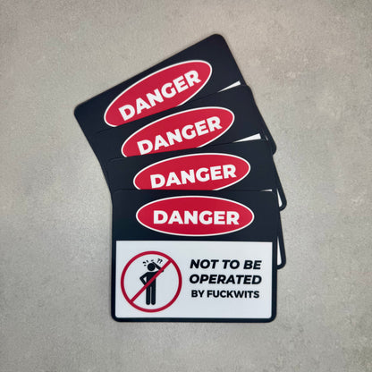 Danger Not To Be Operated By Fuckwits funny magnet stack styled like a classic danger warning sign. Removable novelty toolbox or fridge magnet made using strong 0.8mm magnetic sheeting by Blum Decals UK.