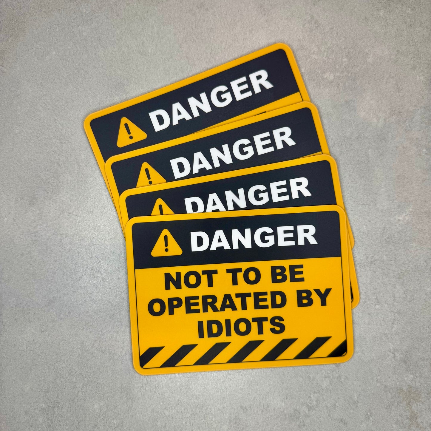 Danger Not To Be Operated By Idiots funny magnet stack styled like an industrial safety warning sign. Removable novelty magnet perfect for garages, vans and toolboxes with matte laminate protection designed in the UK by Blum Decals.