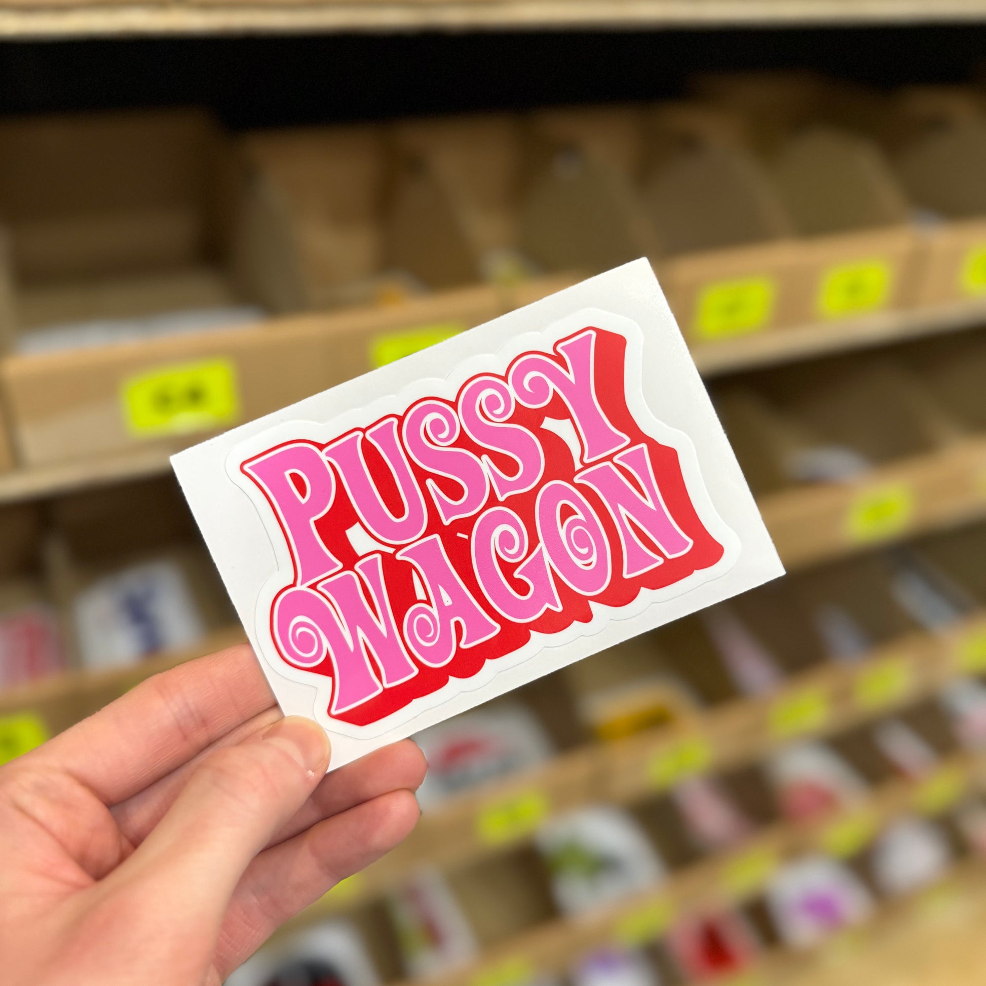 Funny car sticker reading “pussy wagon” in bold black and pink text