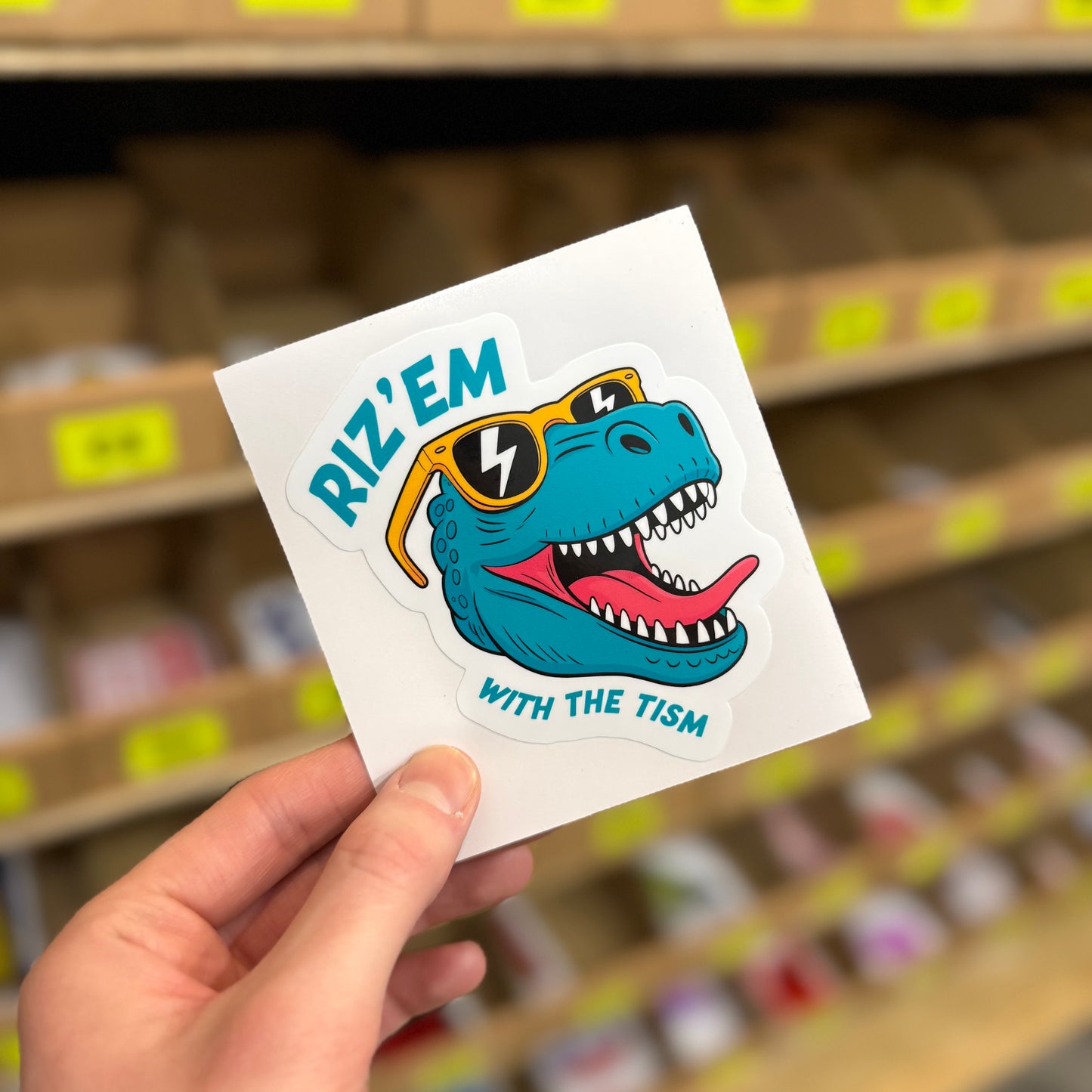 Funny cartoon dinosaur sticker wearing sunglasses with “rizz em with the tism” text