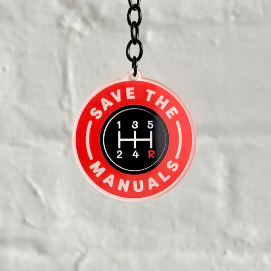 Funny “Save The Manuals” acrylic keychain with gear shift design, glossy finish and black chain, ideal gift for manual car enthusiasts and petrolheads.