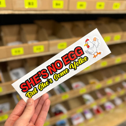 Funny car sticker reading “She’s No Egg But She’s Some Yolk” with cartoon chicken