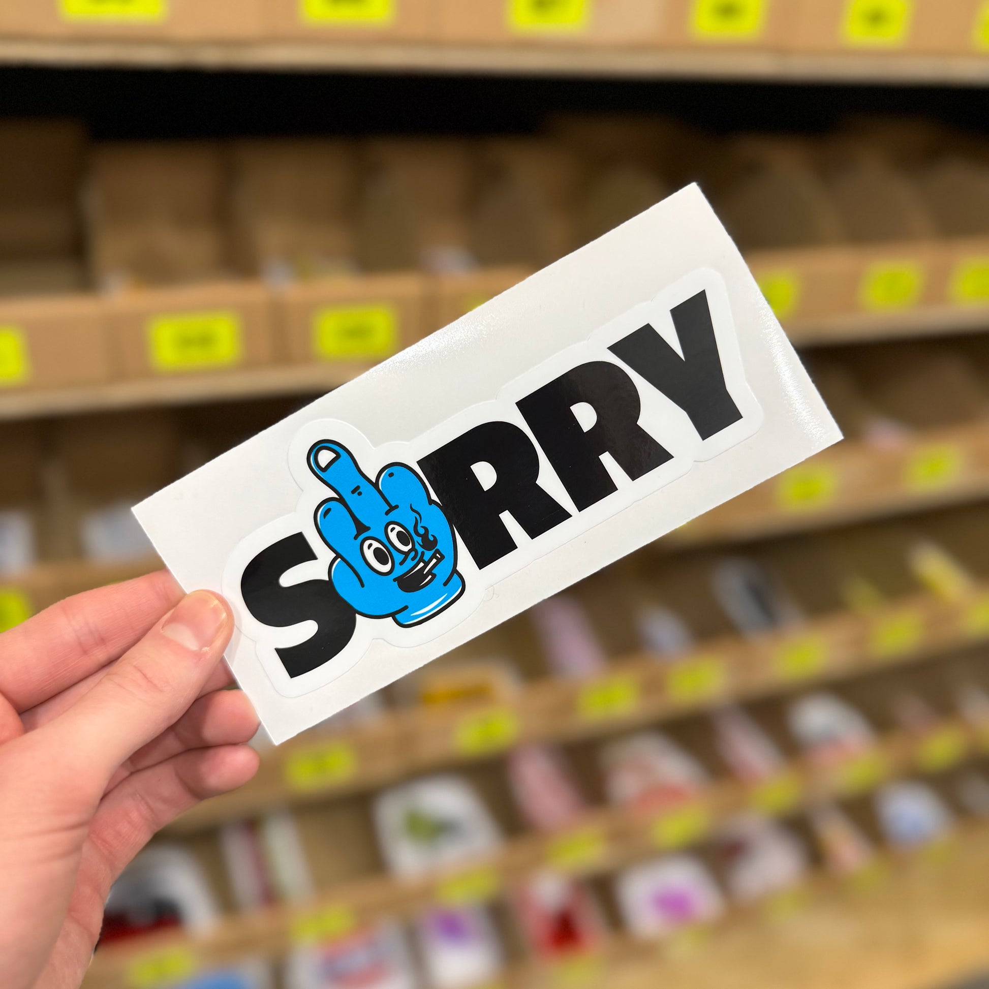 Sorry funny vinyl sticker with blue cartoon hand making rude gesture