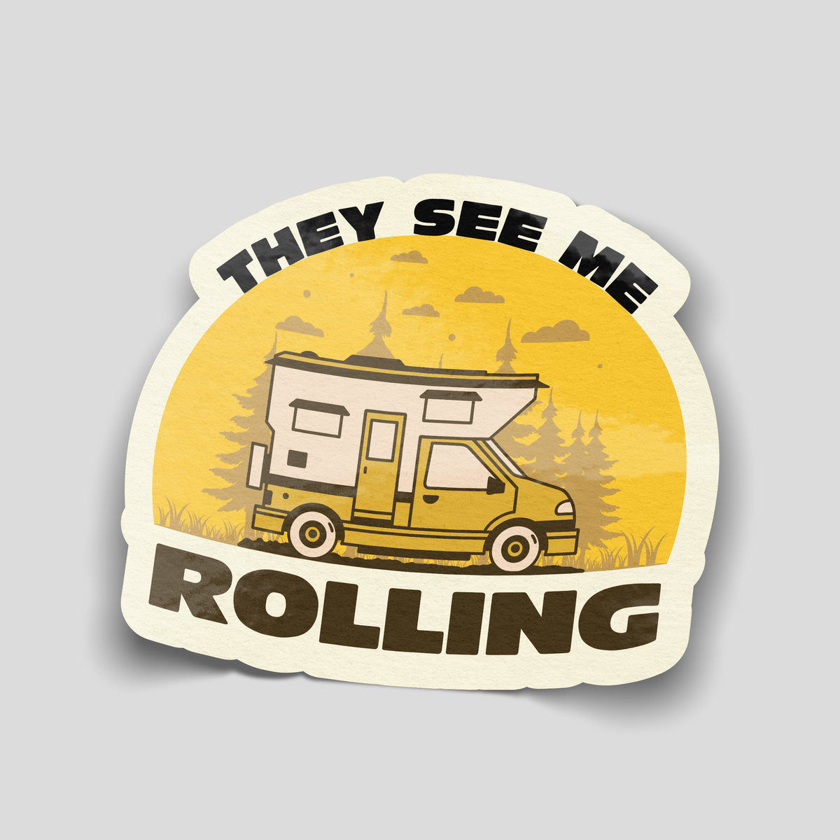 They See Me Rolling sticker featuring a yellow and cream motorhome, pine trees and bold dark lettering against a golden background.