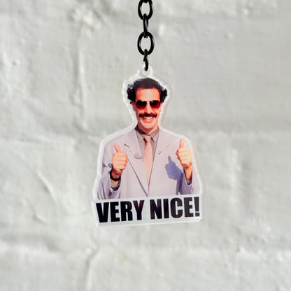 Funny “Very Nice” acrylic keychain with iconic character design, glossy double-sided print and black chain, novelty gift for car lovers.