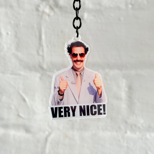Funny “Very Nice” acrylic keychain with iconic character design, glossy double-sided print and black chain, novelty gift for car lovers.