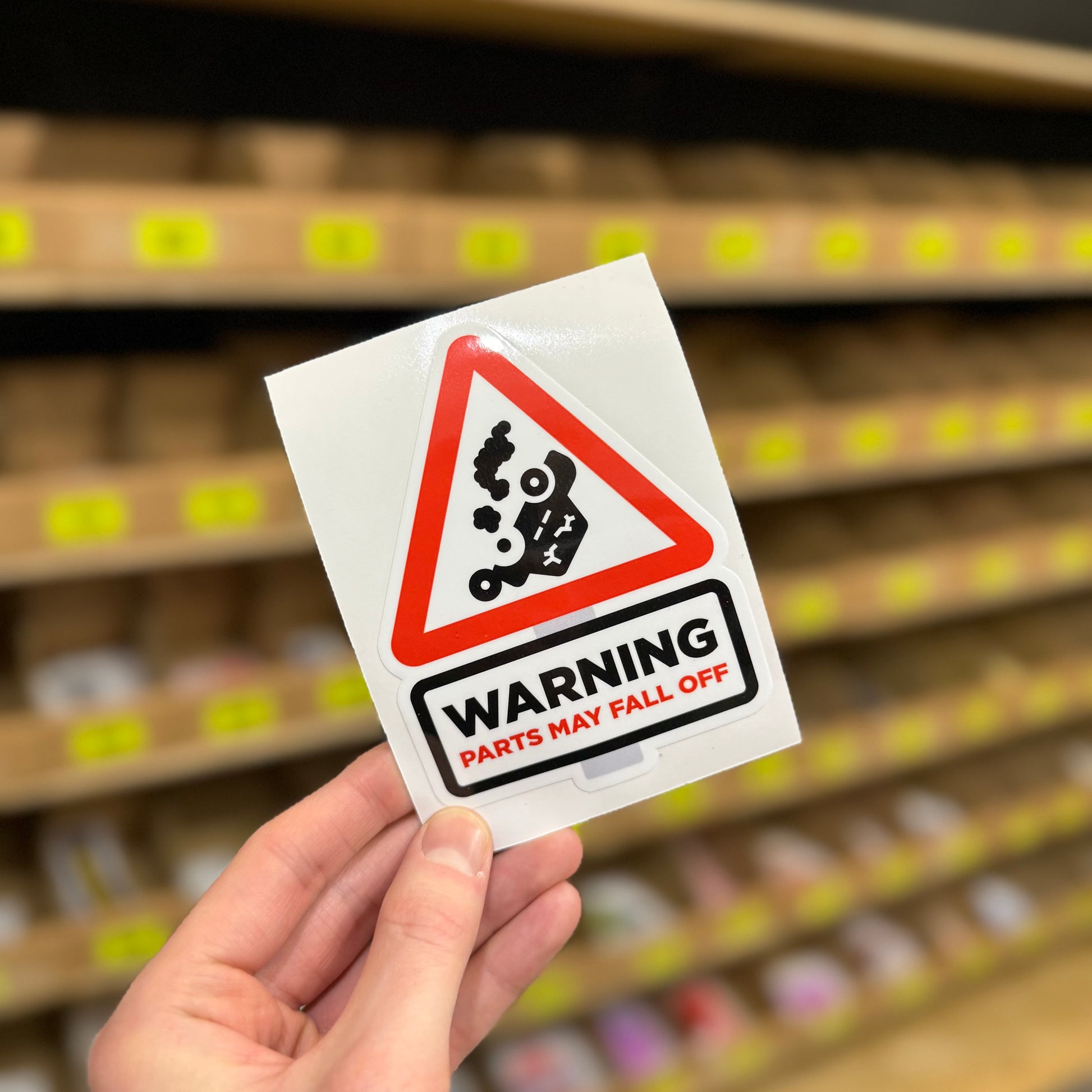 Triangular warning sign reading “Parts may fall off” funny vinyl sticker.