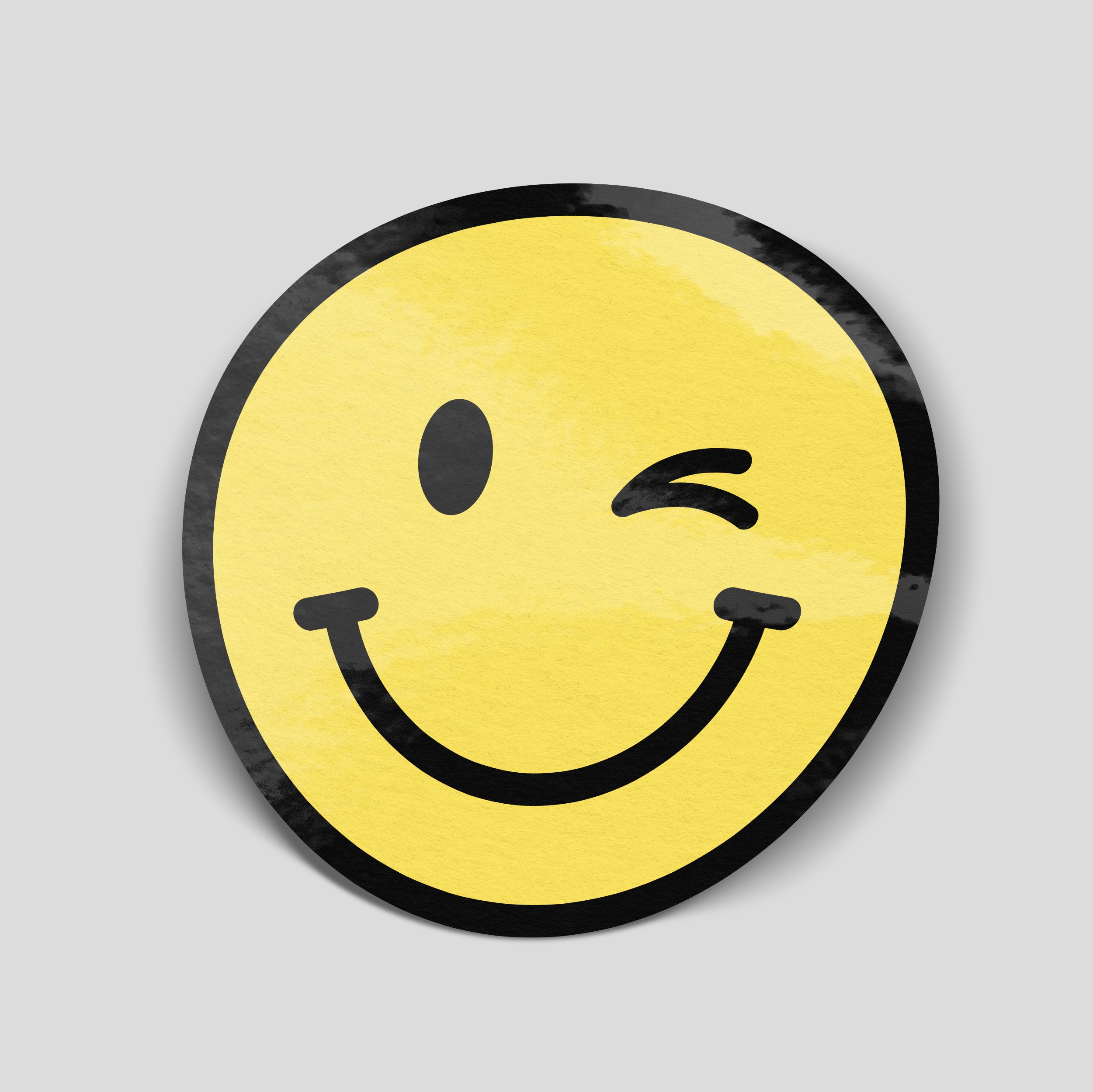 Round yellow winking smiley face vinyl sticker with a black smile, one closed eye and a thick black border.