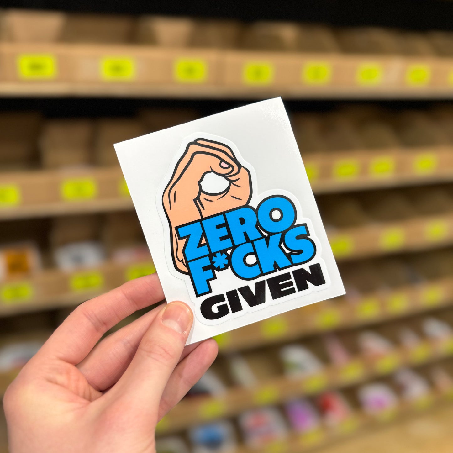 Hand gesture design reading “Zero fcks given” funny vinyl sticker.*